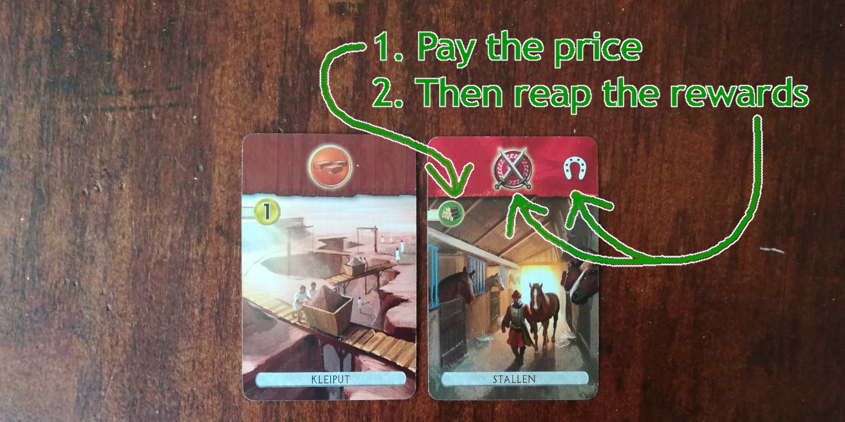 Photo showing two cards. The one on the left is brown, is called Clay Pit and has an image of bricks over an image of a coin. The one on the right is read, is called Stables and has two images, one of a shield and swords and the other of a horse shoe, over an image of some sawed up tree trunks.